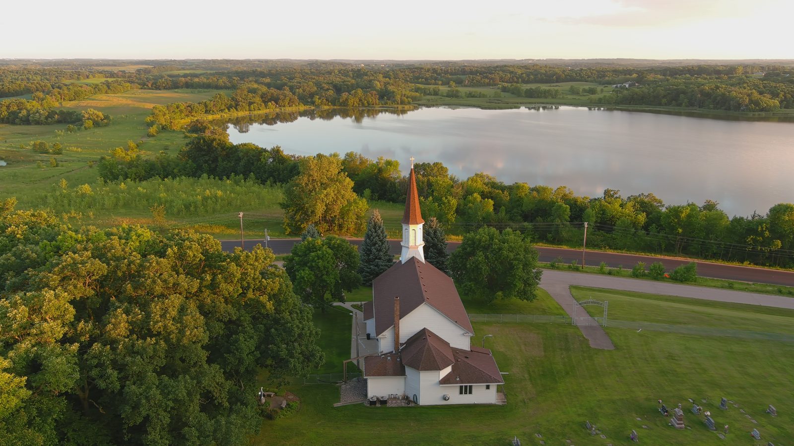 Country church steeple at golden hour from the air